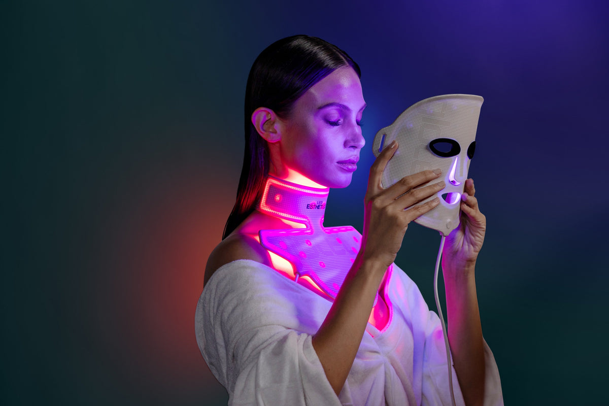 Woman using LED Esthetics red and blue light therapy mask and neck device for anti-aging, skin rejuvenation, and collagen stimulation.