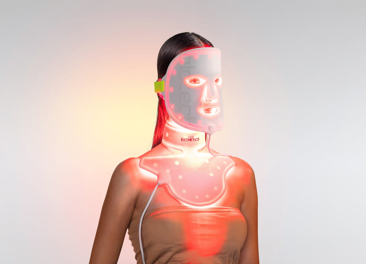 Woman using LED Esthetics GloTech™ LED Light Therapy Face Mask and Neck + Chest Device with red, blue, and infrared light for anti-aging, skin rejuvenation, and collagen stimulation.
