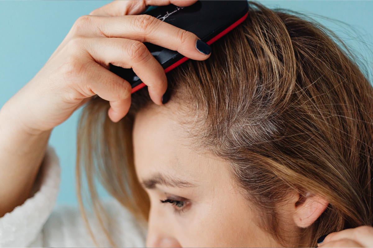 Man using GloTech Hair Pro™ red light therapy cap, showing LED lights activated inside the cap for non-invasive hair regrowth treatment, ideal for thinning hair and scalp health support at home.