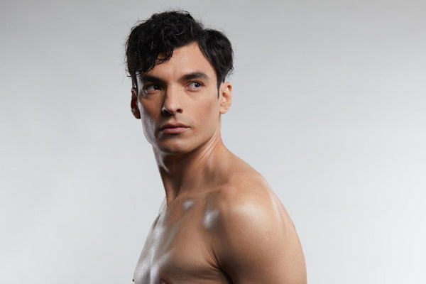 Man with clear skin and defined facial features against a neutral background, illustrating skin quality and appearance in a red light therapy for melasma.