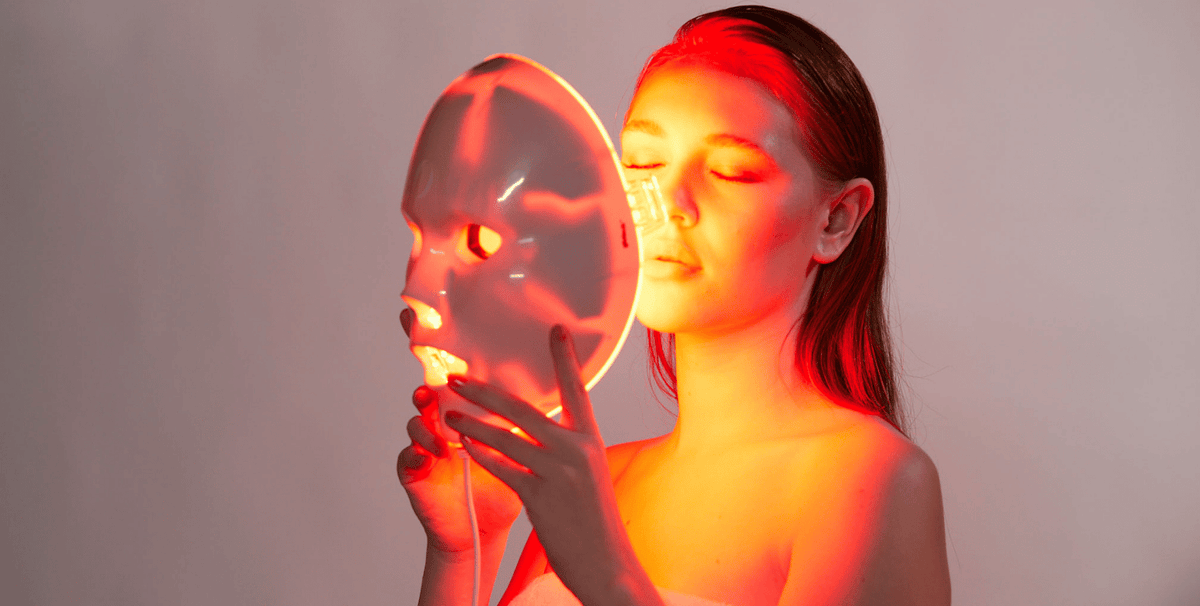 Woman using the Glotech Lite red light therapy mask for skin rejuvenation, collagen support and post-treatment recovery.