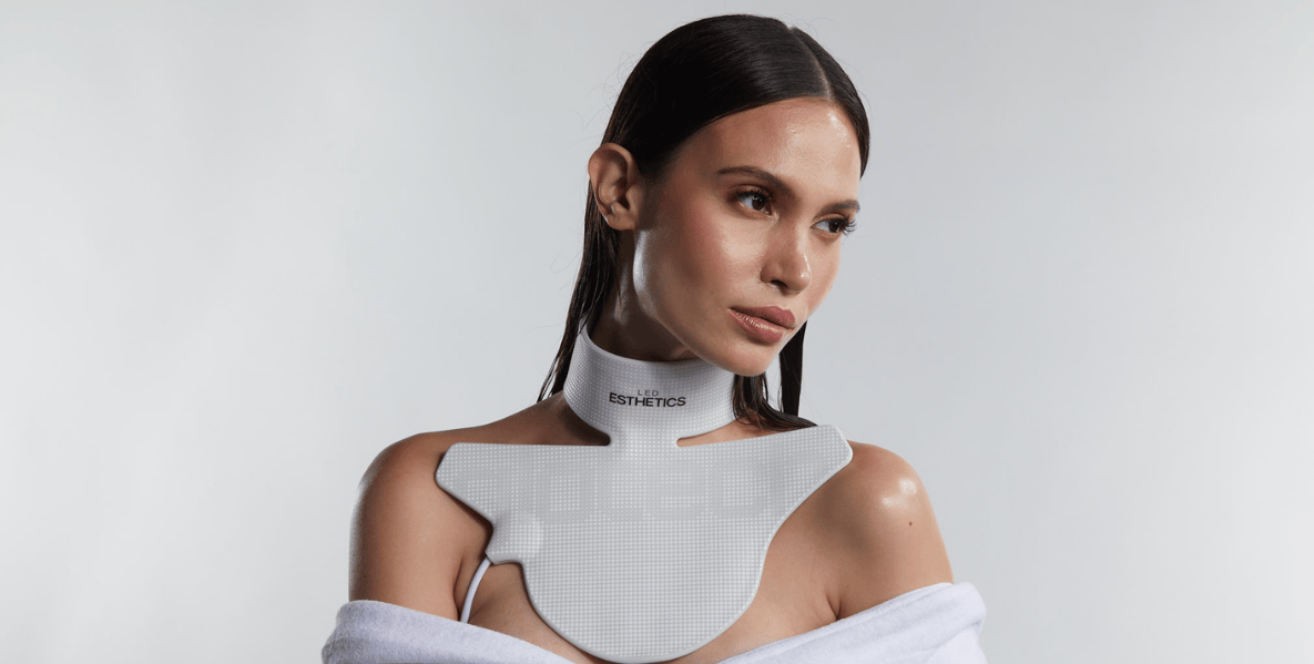Woman wearing the Glotech Collar red light therapy neck device to reduce wrinkles and improve skin firmness on the neck area.